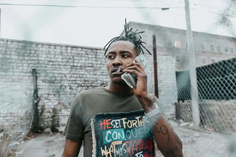 a man with dreadlocks talking on a cell phone, by Bascove, trending on pexels, graffiti, playboi carti portrait, wearing a shirt, gunplay, promotional image