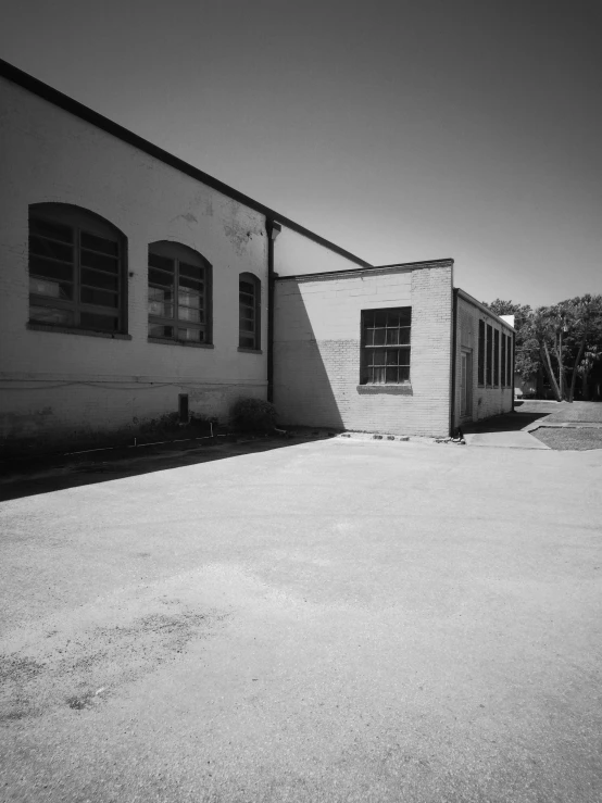 a black and white photo of a building, a black and white photo, by Adam Chmielowski, northwest school, on the concrete ground, shady alleys, industrial buildings, low quality photograph