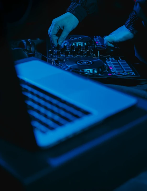 a dj mixing music in front of a laptop, trending on unsplash, computer art, portrait of computer & circuits, ilustration, high angle shot, moody blue lighting