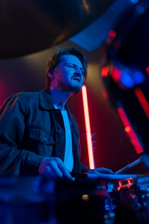 a man that is playing some kind of musical instrument, featured on reddit, bauhaus, blue neon lights, mark edward fischbach, philip selway (drums), profile image