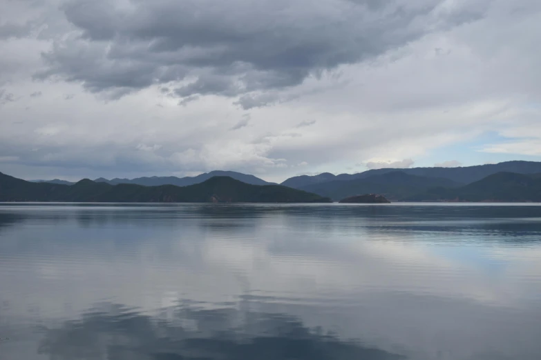 a large body of water with mountains in the background, by Charlotte Harding, hurufiyya, overcast lighting, lake blue, in chuquicamata, today\'s featured photograph 4k