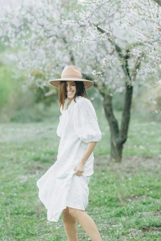 a woman in a white dress and hat walking through a field, flowing sakura silk, wearing a linen shirt, style of paolo parente, promotional image
