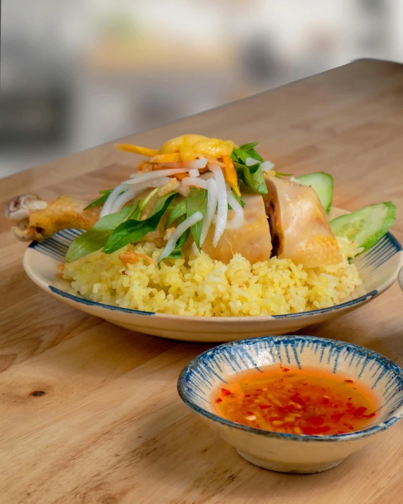 a wooden table topped with two plates of food, in style of lam manh, profile image, yellow, chicken