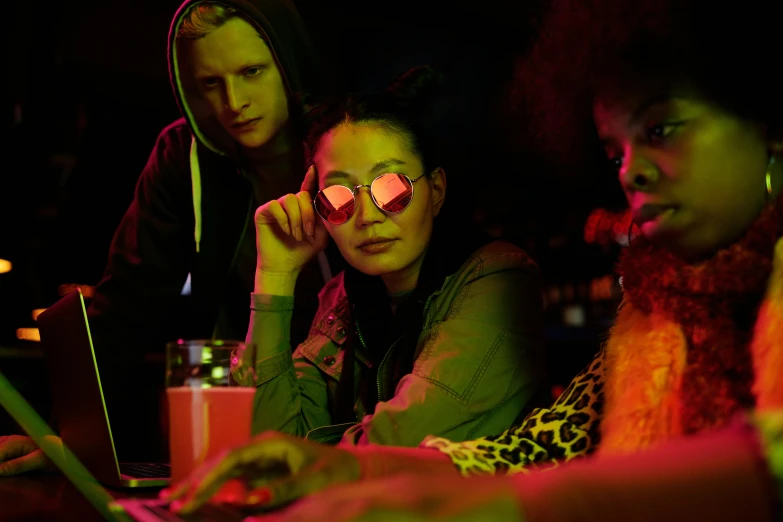 a group of women sitting in front of a laptop computer, a portrait, inspired by Nan Goldin, pexels, funk art, neon lenses, three cats drinking in a bar, nvidia promotional image, shades