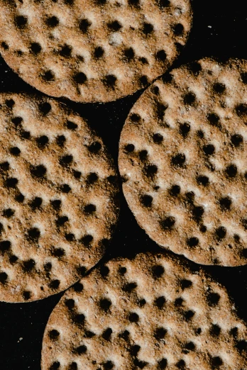 a bunch of cookies sitting on top of a table, an album cover, by Adam Chmielowski, hyperrealism, pattern, craters, medium closeup, crypto
