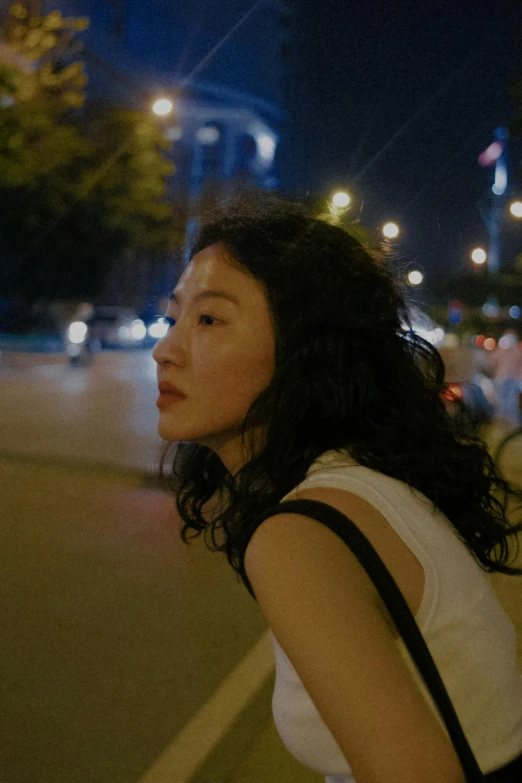 a woman walking down a street at night, inspired by Zhang Xuan, pexels contest winner, serial art, looking to the side off camera, movie still of a tired, her face framed with curls, summer evening