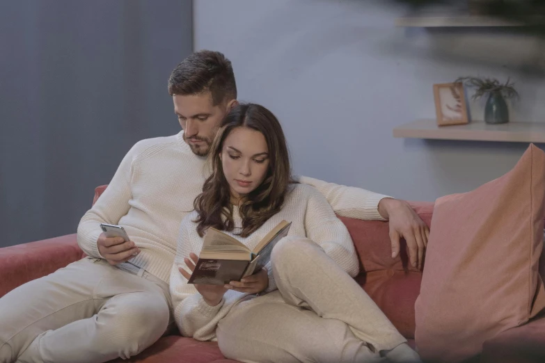 a man and woman sitting on a couch reading a book, by Adam Marczyński, pexels, renaissance, home video footage, avatar image, handsome girl, youtube thumbnail