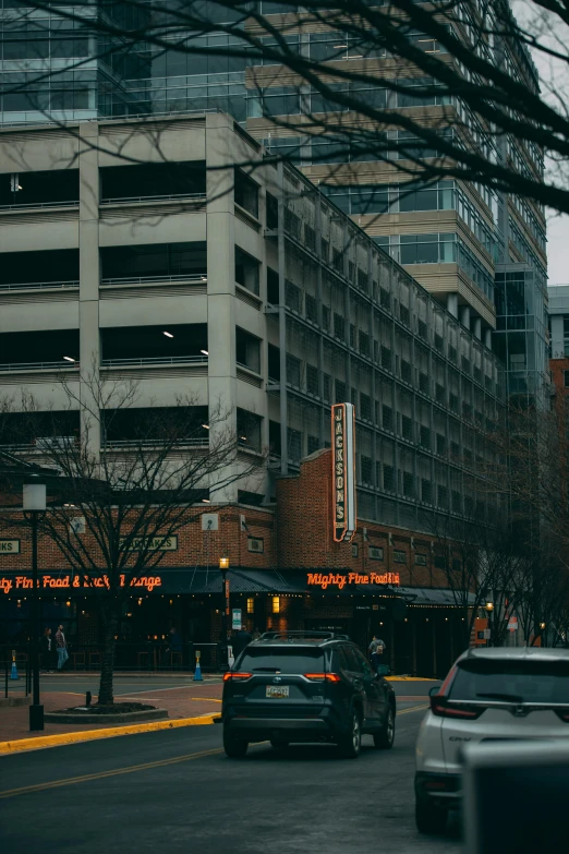 a city street filled with lots of traffic next to tall buildings, by Washington Allston, trending on pexels, bleak lighting, set inside of parking garage, cinematic movie photo, low fi