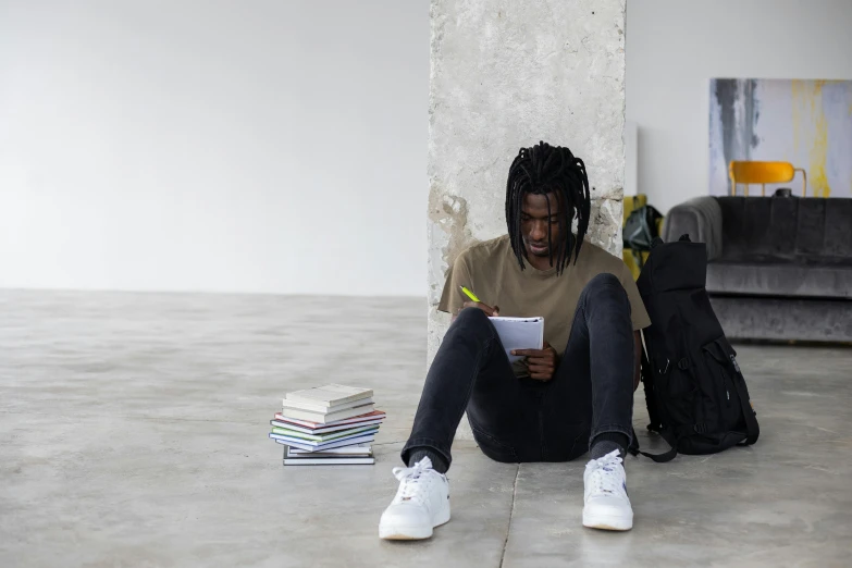 a man sitting on the floor reading a book, pexels contest winner, academic art, chief keef, with a backpack, background image, man is with black skin