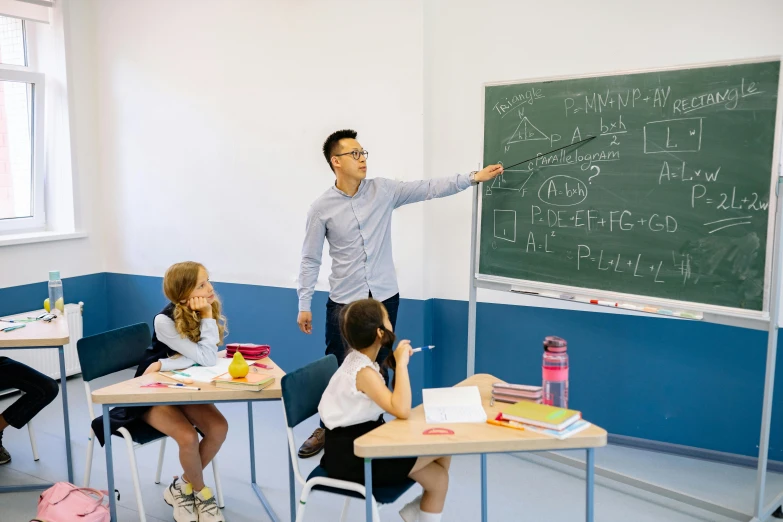 a man standing in front of a blackboard in a classroom, danube school, ismail inceoglu and ruan jia, threes, thumbnail, center of image