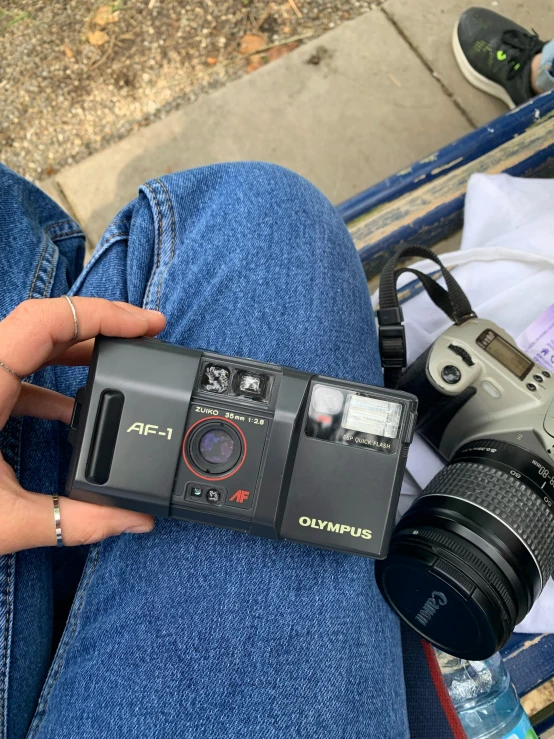 a person sitting on a bench holding a camera, taken on a 1990s camera, photograph taken in 2 0 2 0, aperture f12, high angle camera