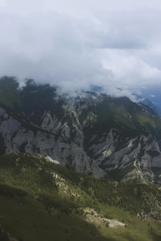 a man flying a kite on top of a lush green hillside, by Muggur, les nabis, mount olympus, covered in clouds, today\'s featured photograph 4k, alps