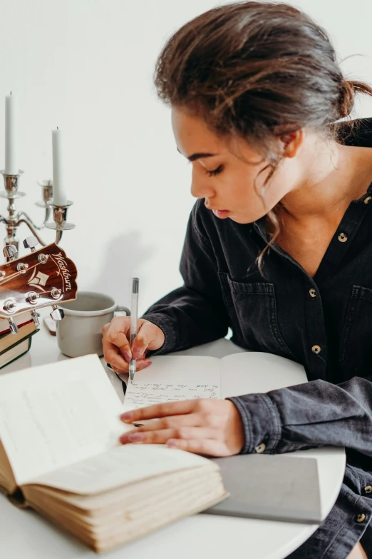 a woman sitting at a table writing on a book, pexels contest winner, detailed expression, indi creates, high quality photo, 1 2 9 7