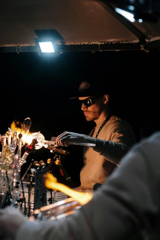 a man that is standing in front of a bar, unsplash, kinetic art, holding a torch, amber glasses, showstudio, he is in a alchemist lab