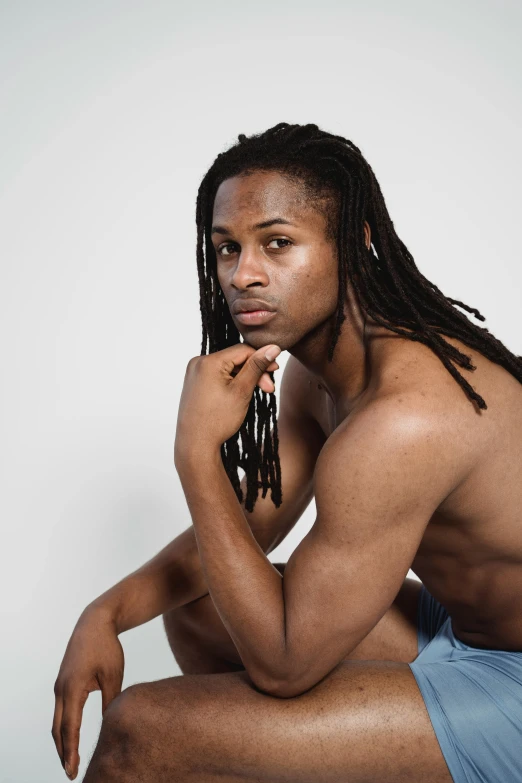 a man with dreadlocks sitting on a stool, by Terrell James, trending on pexels, renaissance, wearing a low cut tanktop, non binary model, young with long hair, ( ( dark skin ) )