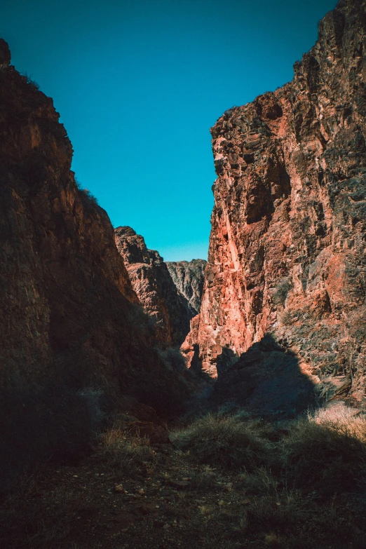 a person standing in the middle of a canyon, hyper - detailed color photo, high light on the left, instagram story, unsplash photography