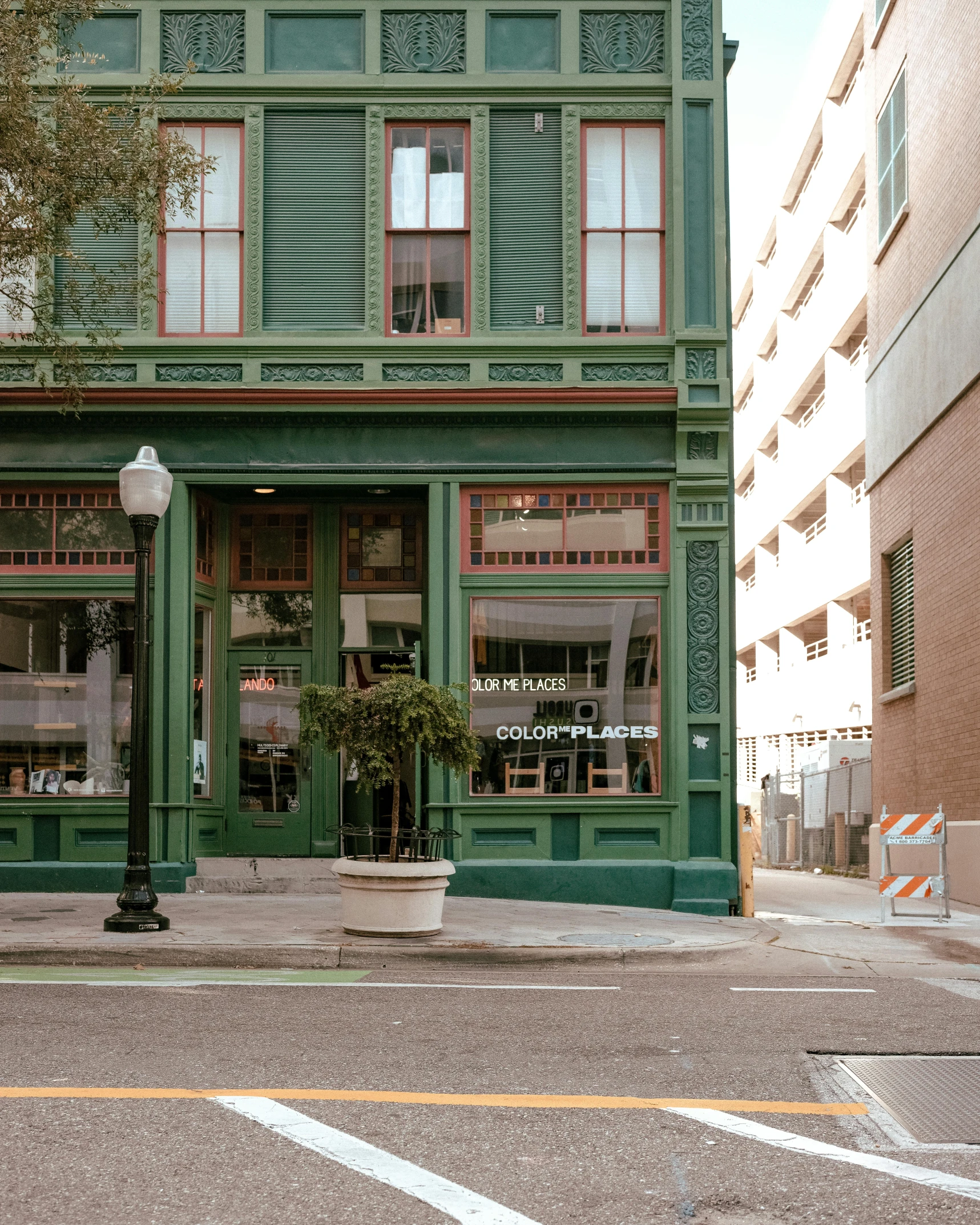 a green building on the corner of a street, by Carey Morris, pexels contest winner, exiting store, front facing, vintage inspired, downtown