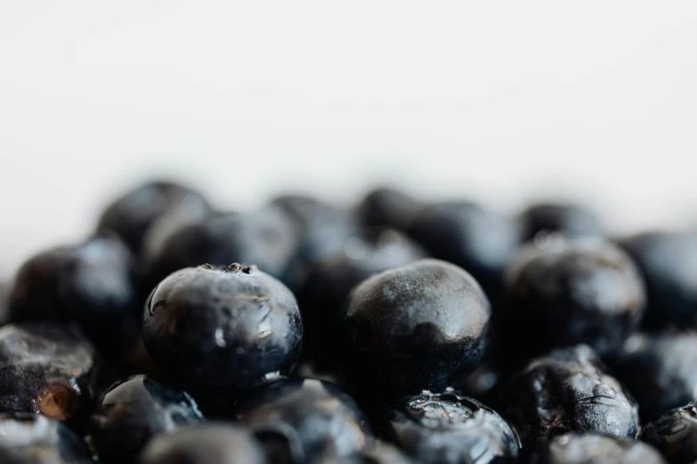 a pile of blueberries sitting on top of a table, by Carey Morris, trending on unsplash, profile image, background image, close-up product photo, black on white background