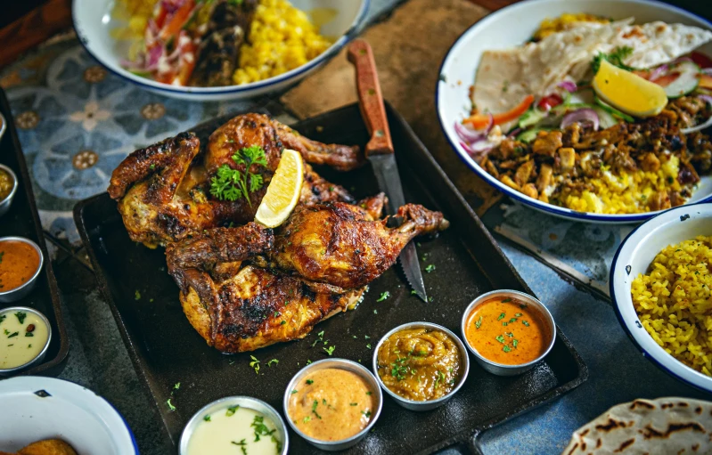 a table topped with lots of different types of food, a photo, grilled chicken, african ameera al taweel, thumbnail, brown