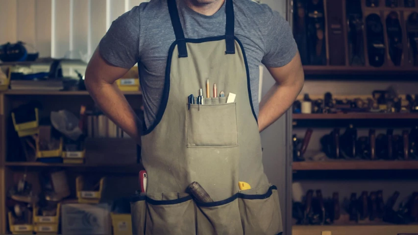 a man standing with his hands in his pockets, inspired by Grant Wood, pexels contest winner, arbeitsrat für kunst, blacksmith apron, holding paintbrushes, product design shot, at home