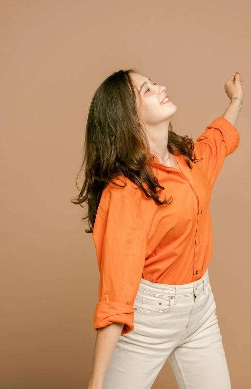 a woman reaching up to catch a frisbee, an album cover, by Gavin Hamilton, trending on pexels, wearing an orange t shirt, wearing a linen shirt, brunette woman, celebration