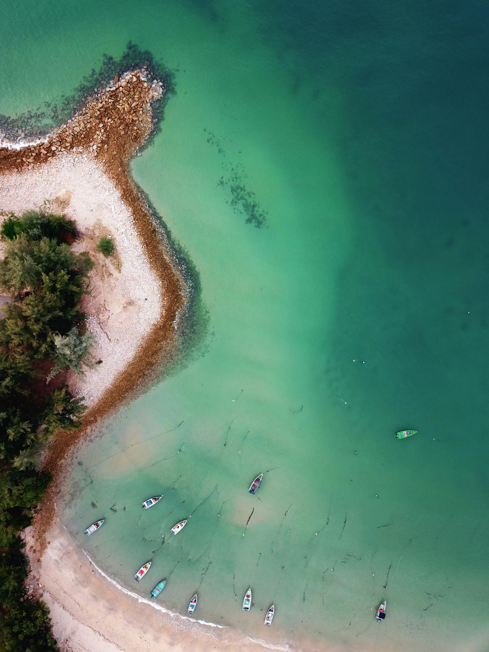 a large body of water next to a sandy beach, pexels contest winner, top down shot, boats in the water, thumbnail, greenish colors