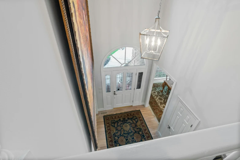 a view from the top of the stairs of a house, a picture, tall entry, listing image, profile image, gallery lighting