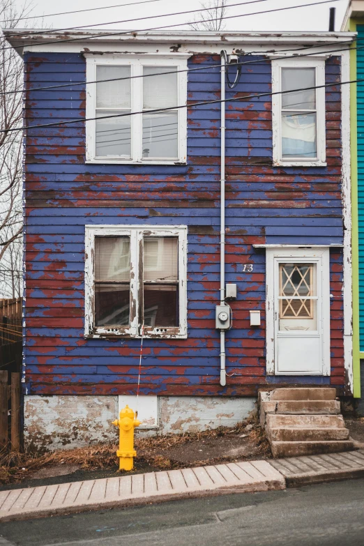 a blue house with a yellow fire hydrant in front of it, a colorized photo, inspired by Elsa Bleda, pexels contest winner, photorealism, brown red blue, pittsburgh, very poor, white plank siding