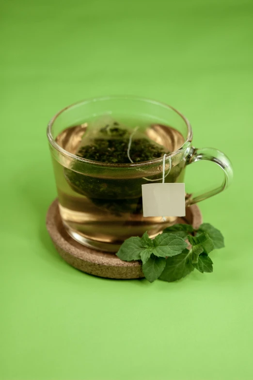 a cup of tea sitting on top of a wooden coaster, a digital rendering, by Andries Stock, pexels, hurufiyya, mint leaves, thumbnail, plants in a glass vase, realistic photo of delicious pho