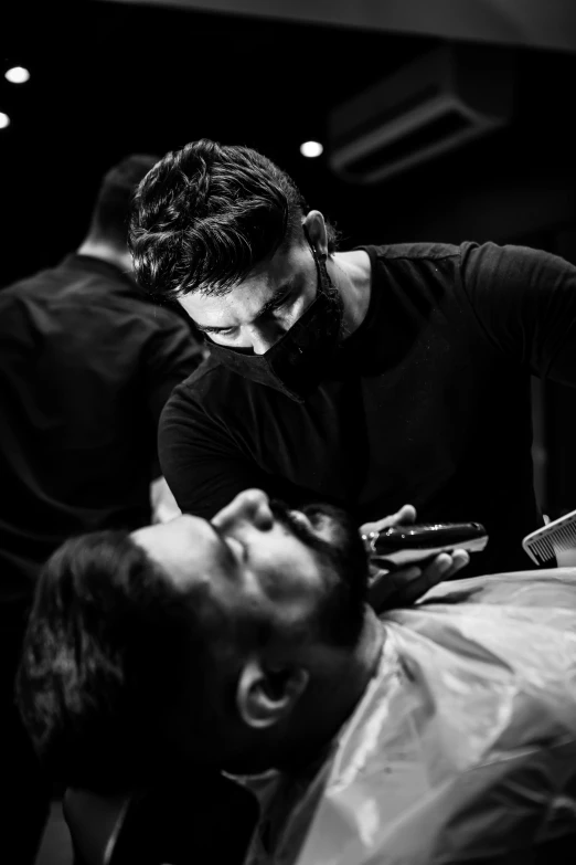 a man getting his hair cut at a barber shop, a black and white photo, by Adam Marczyński, pexels contest winner, square masculine jaw, 1614572159, bearded, mid night