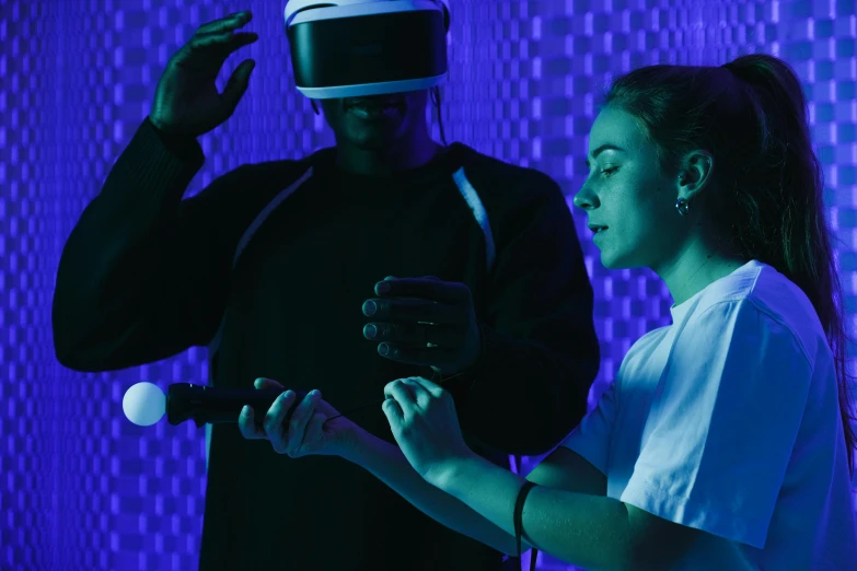 a woman standing next to a man holding a bat, a hologram, pexels, interactive art, wearing a vr headset, black and blue and purple scheme, digital medical equipment, thumbnail