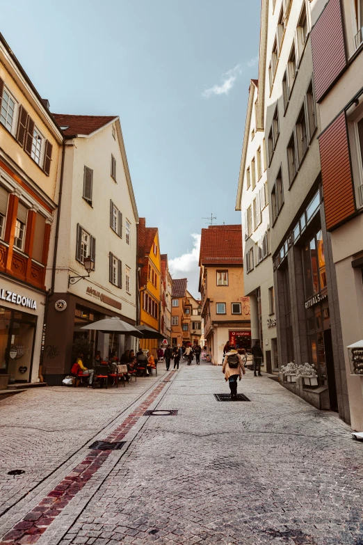 a narrow cobblestone street in a european city, an album cover, inspired by Karl Stauffer-Bern, pexels contest winner, renaissance, ocher, people shopping, wide view, today\'s featured photograph 4k