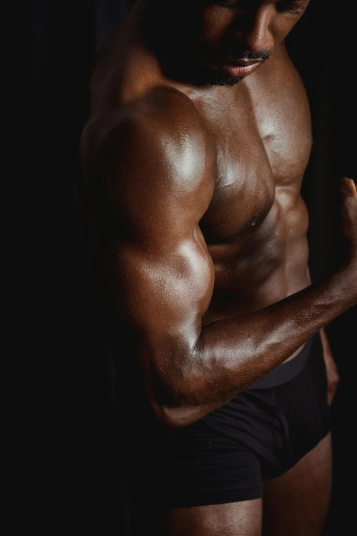 a man standing in front of a black background, muscular arms, dark skin tone, steroid use, with grey skin