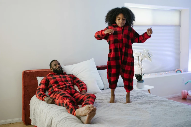 a man and a little girl in pajamas on a bed, inspired by Myles Birket Foster, pexels contest winner, black and red suit, lumberjack, african american, performing