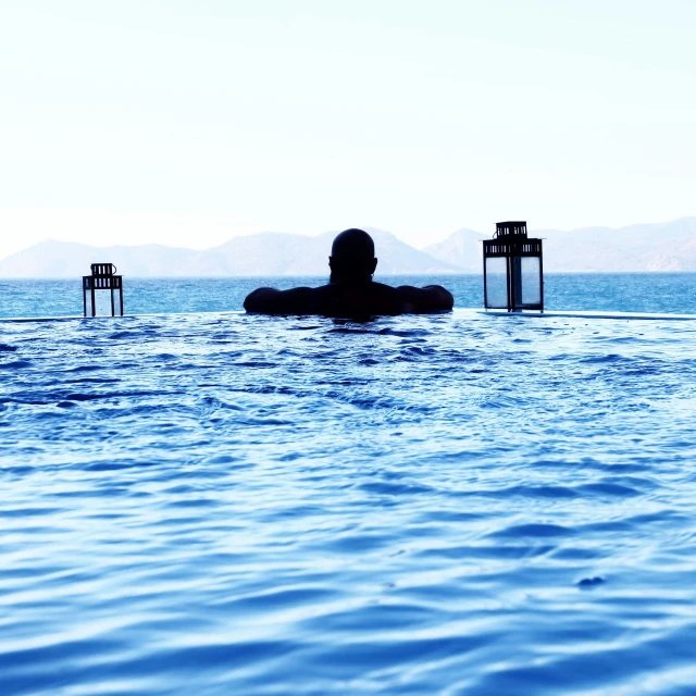 a man sitting in the middle of a swimming pool, middle of the ocean, luxurious onsens, skye meaker, hamar