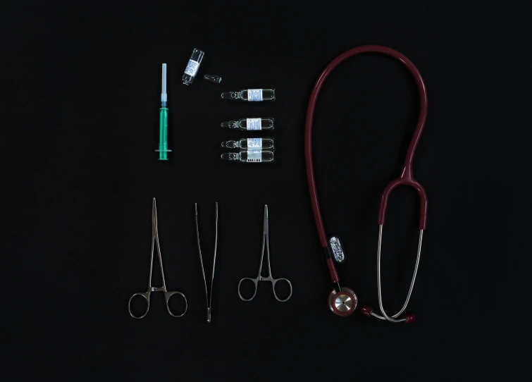 a red stethoscope sitting on top of a black table, a picture, unsplash, assemblage, syringes, collection product, air shot, portrait n - 9
