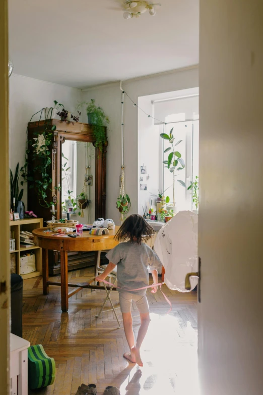 a little girl that is standing in a room, by Isabel Naftel, pexels contest winner, process art, room full of plants, apartment, with a mirror, kid and mad scientist walking