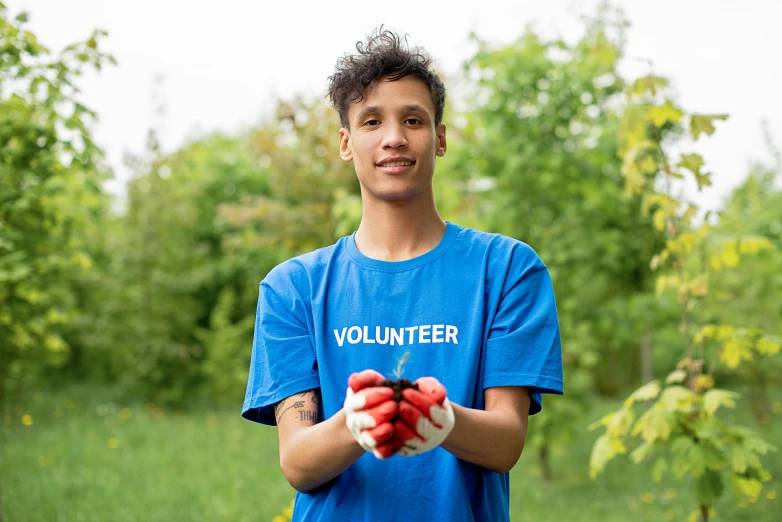 a young man holding a handful of cherries in his hands, by Francis Helps, pexels contest winner, graffiti, healthcare worker, standing in an apple orchard, avatar image