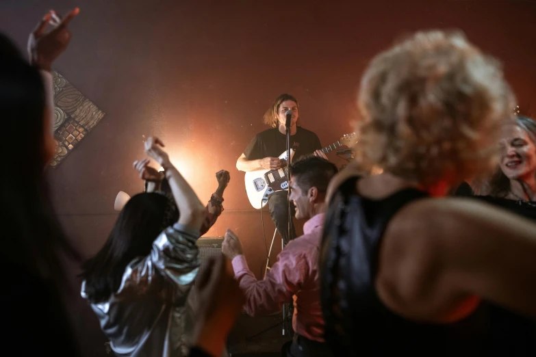 a group of people standing on top of a stage, an album cover, pexels, happening, the guitar player, movie scene close up, ( ( theatrical ) ), lachlan bailey