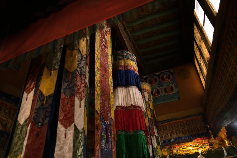 a group of flags hanging from the ceiling of a building, tibetan inspired architecture, deep colour, 🦩🪐🐞👩🏻🦳, thumbnail