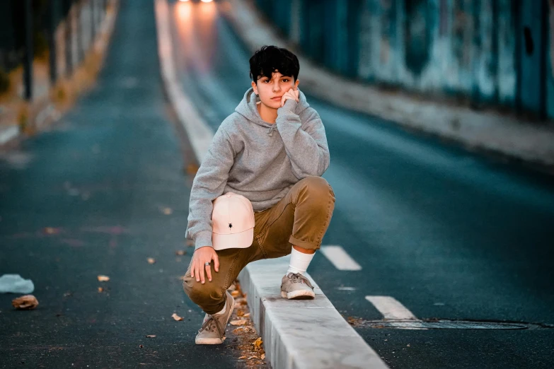 a young man squatting on the side of a road, pexels contest winner, realism, avatar image, grey hoodie, male teenager, asher duran