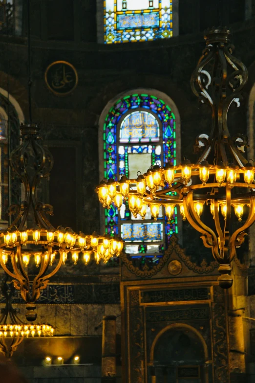 a chandelier and stained glass windows in a church, inspired by Louis Comfort Tiffany, art nouveau, jerusalem, “ golden chalice, wrought iron architecture, taken in the early 2020s