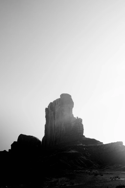 a black and white photo of a rock formation, unsplash, postminimalism, temple of the sun, smokey chimney, medium format. soft light, silhouetted