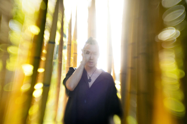 a woman standing in a bamboo forest talking on a cell phone, an album cover, unsplash, conceptual art, a portrait of issey miyake, discreet lensflare, portrait of chester bennington, medium format. soft light