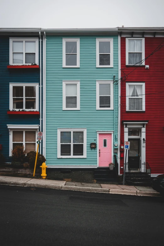 a row of multicolored houses on a street, by Jessie Algie, pexels contest winner, tall door, teal silver red, new england architecture, paul barson