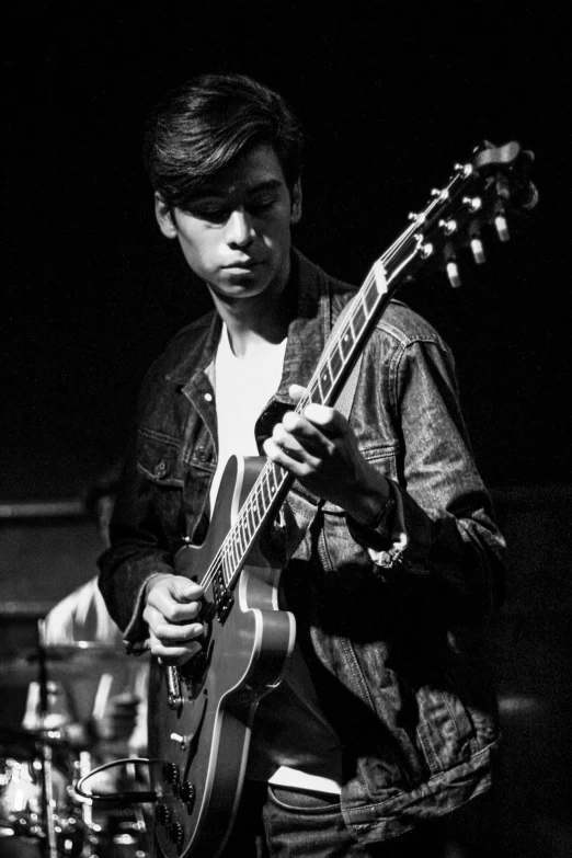 a black and white photo of a man playing a guitar, by Dave Melvin, declan mckenna, playing a gibson les paul guitar, ariel perez, uploaded