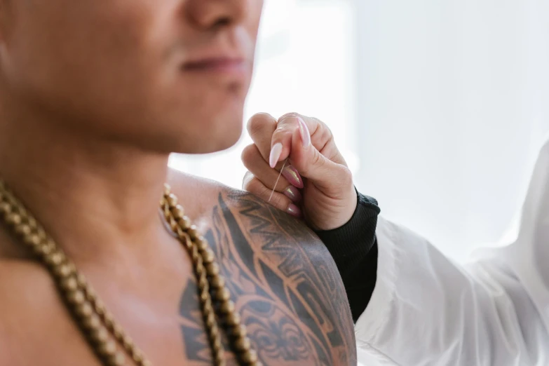 a man getting a tattoo on his arm, unsplash, te pae, native rich jewelry, looking her shoulder, morning detail