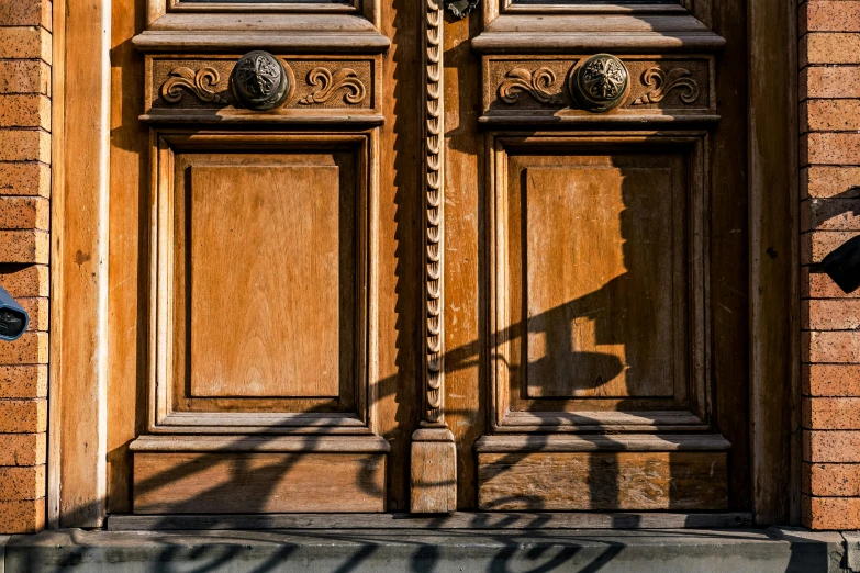 a motorcycle parked in front of a wooden door, by Sven Erixson, pexels contest winner, arts and crafts movement, sun and shadow over a city, intricate carved wood, style of atget, a wooden