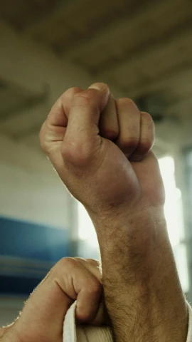 a close up of a person holding a banana, by Andrew Domachowski, closeup of fist, in a gym, square, prideful