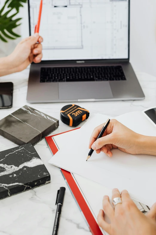 a couple of people sitting at a table with a laptop, marking lines, 9 9 designs, thumbnail, high-quality photo